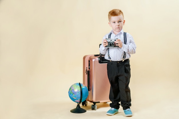 Niño pelirrojo con una cámara retro en manos