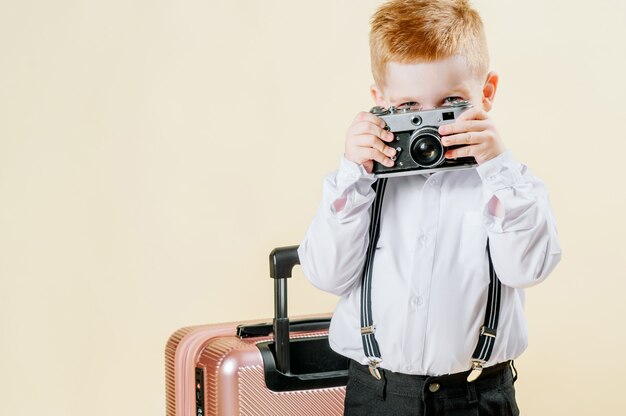 Niño pelirrojo con una cámara retro en manos