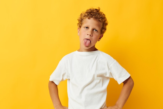 Niño con pelo rizado infancia posando fondo amarillo