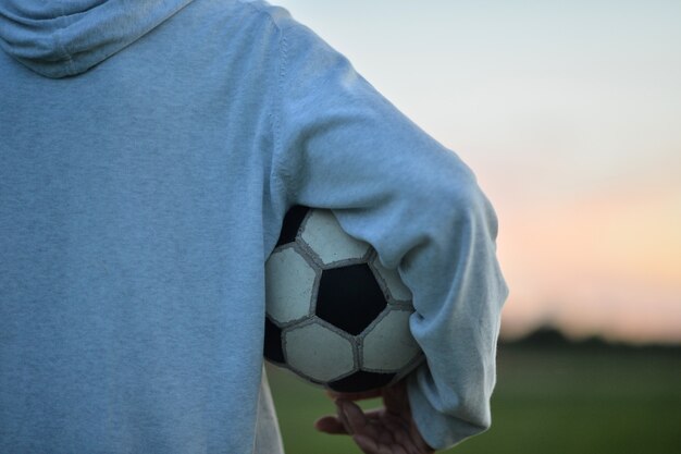 Foto niño con una pelota de fútbol en el campo