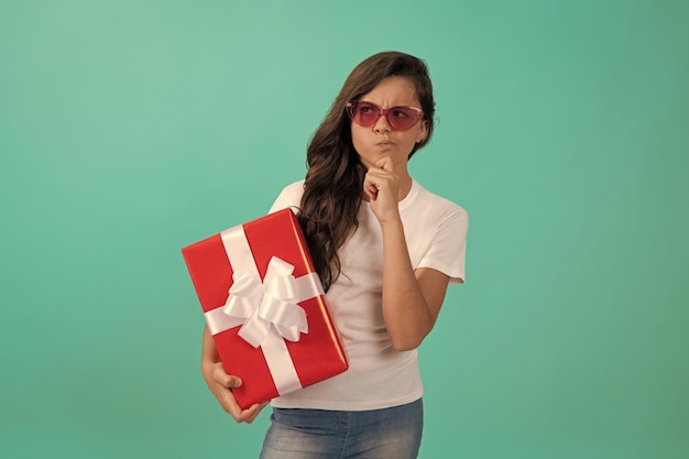 Niño de pensamiento de moda en gafas de sol con caja de regalo vacaciones