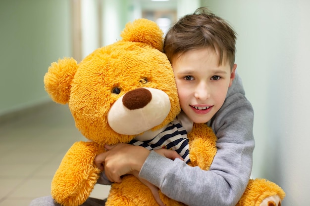 Un niño pequeño abraza a un oso de peluche esponjoso