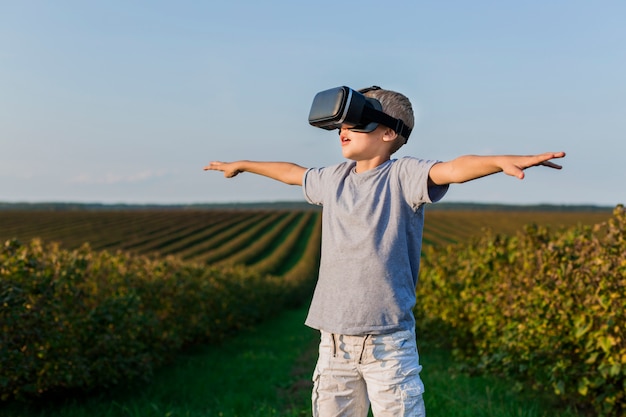 Niño pequeño adorable divirtiéndose con gafas de realidad virtual