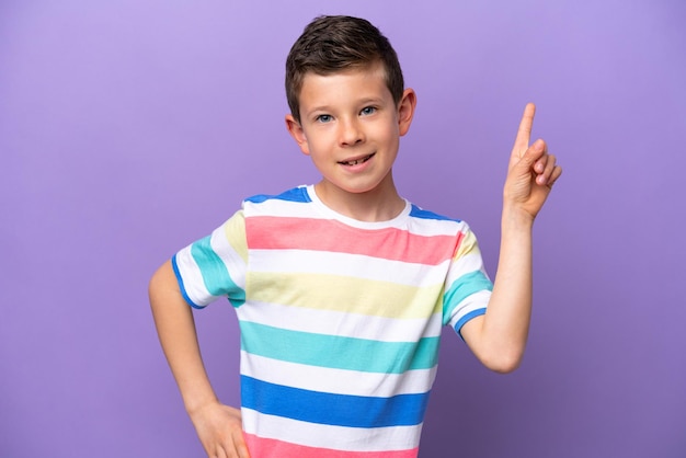 Niño pequeño aislado de fondo morado mostrando y levantando un dedo en señal de lo mejor