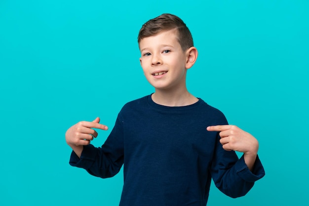 Niño pequeño aislado sobre fondo azul orgulloso y satisfecho de sí mismo