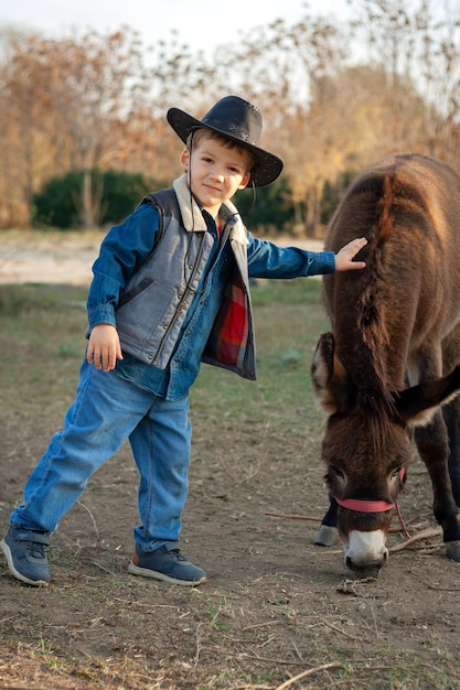 niño pequeño alimentando verduras de burro