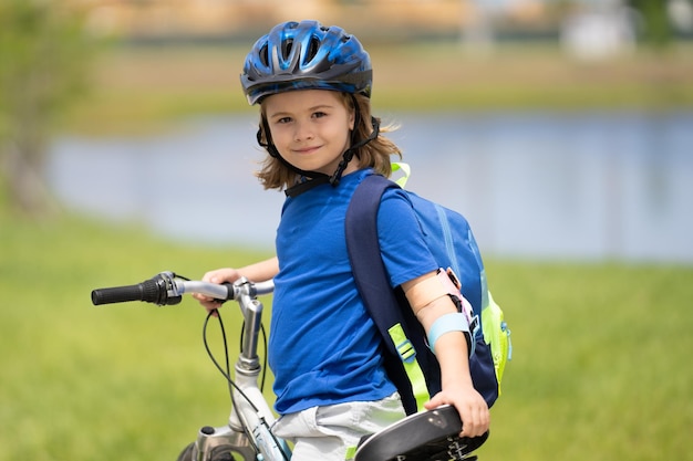 Niño pequeño andar en bicicleta en el parque niño andar en bicicleta feliz niño sonriente en casco ridin