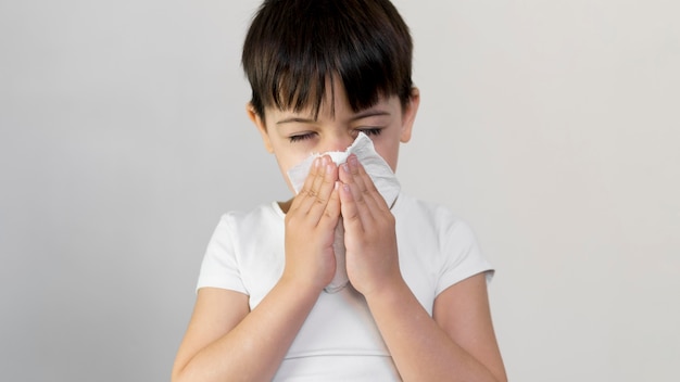 Niño pequeño ángulo alto sonarse la nariz