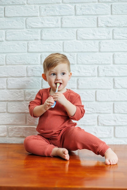 Un niño pequeño aprende a cepillarse los dientes con un cepillo de dientes. Higiene dental en niños.