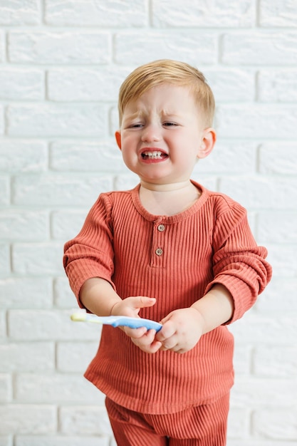 Un niño pequeño aprende a cepillarse los dientes con un cepillo de dientes. Higiene dental en niños.