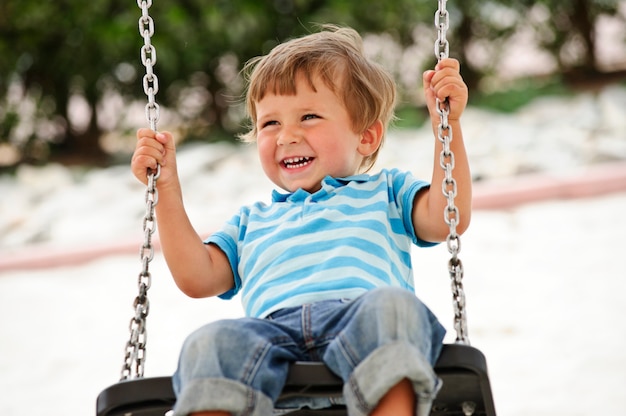 Niño pequeño balanceándose en la vista de la playa