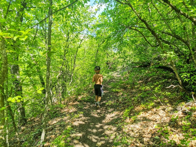 Un niño pequeño en el bosque cerca de la ciudad cueva de TepeKermen Crimea Rusia 2021