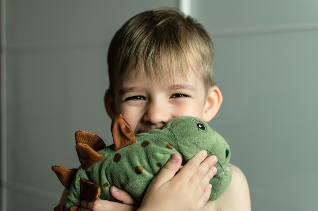 un niño pequeño con cabello rubio abraza un juguete suave