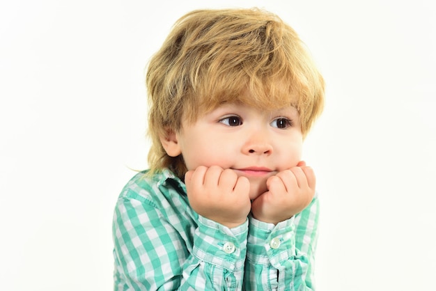 Niño pequeño en camisa verde niño tiene la cara en las manos niño esperando cerrar retrato poco de moda