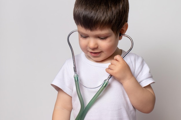 Niño pequeño con una camiseta blanca con un estetoscopio médico