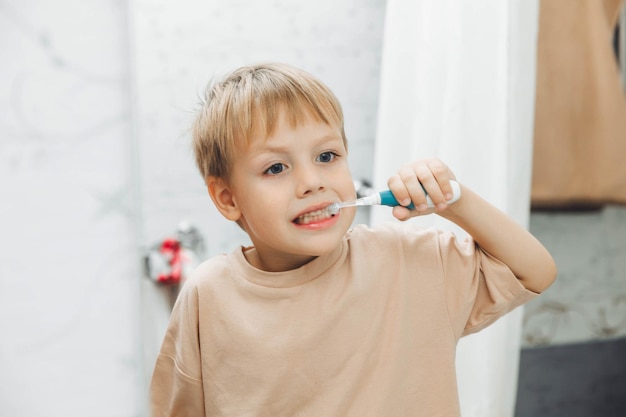 Un niño pequeño cepillándose los dientes en el baño de casa.