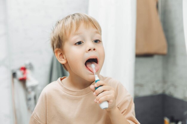 Un niño pequeño cepillándose los dientes en el baño de casa.