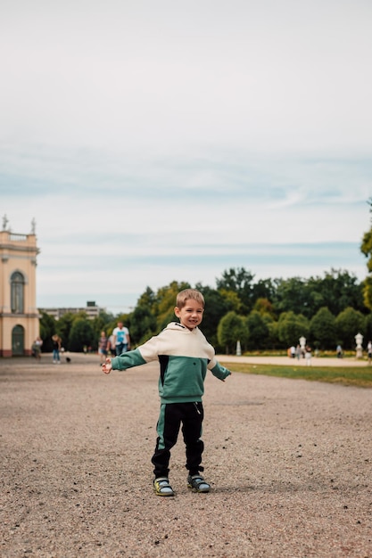 Un niño pequeño en un chándal se encuentra en una gran plaza en Europa