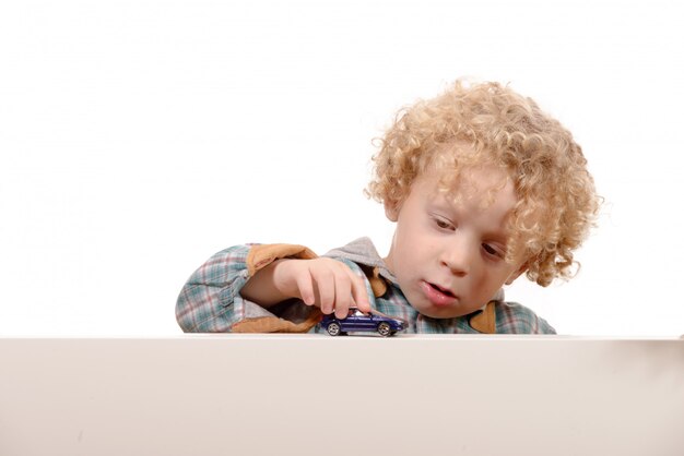 Niño pequeño con coche de juguete