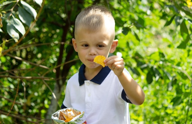 El niño pequeño come papas fritas.