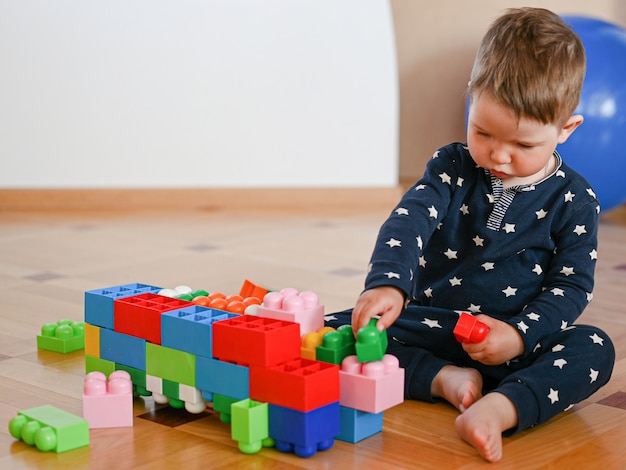 El niño pequeño construye figuras del constructor