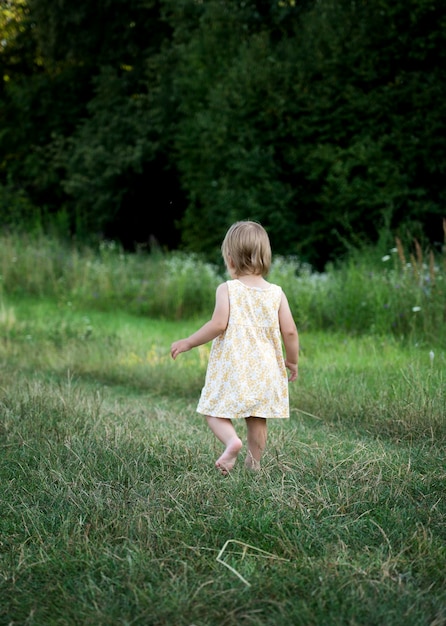 Un niño pequeño corre por un camino en el parque, vista trasera