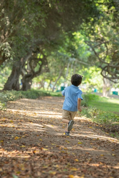 Niño pequeño corriendo alegremente en un parque libertad de la infancia