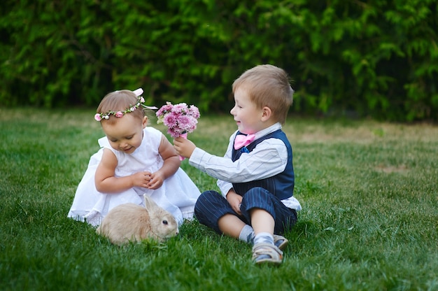 Un niño pequeño le da a una niña un ramo de flores.