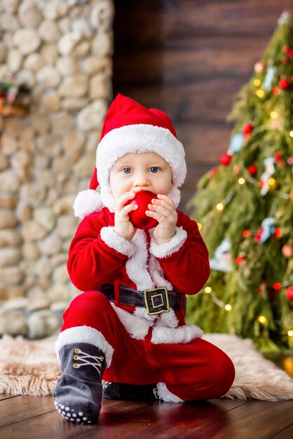 Un niño pequeño con un disfraz rojo de Santa Claus