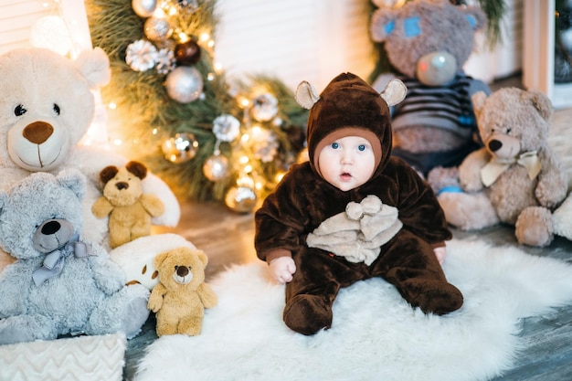 Un niño pequeño disfrazado de oso de peluche marrón se sienta en el suelo