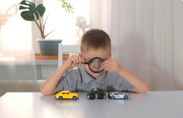 Un niño pequeño disfruta de los autos coloridos, juega con ellos en una mesa grande, ríe y disfruta de sus juguetes.