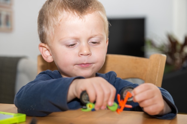 Foto niño pequeño dos años jugando con sus juguetes