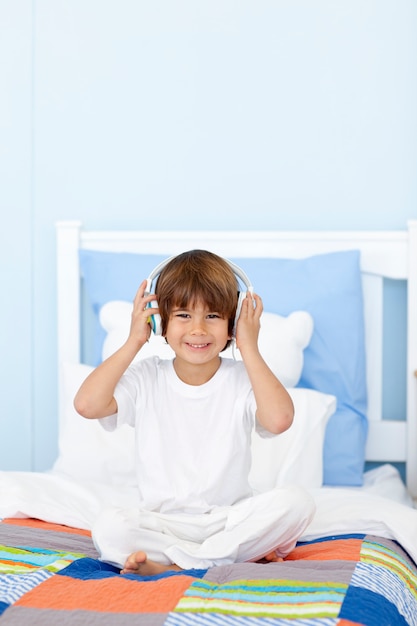 Niño pequeño escuchando música en su cama