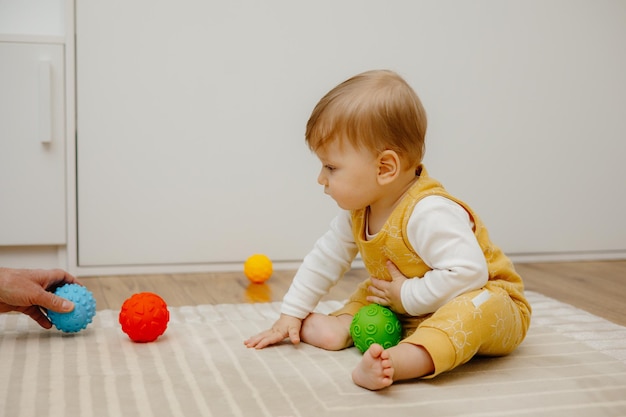 El niño pequeño está jugando con bolas sensoriales.