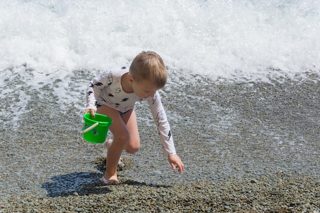 Un niño pequeño está jugando en la playa.