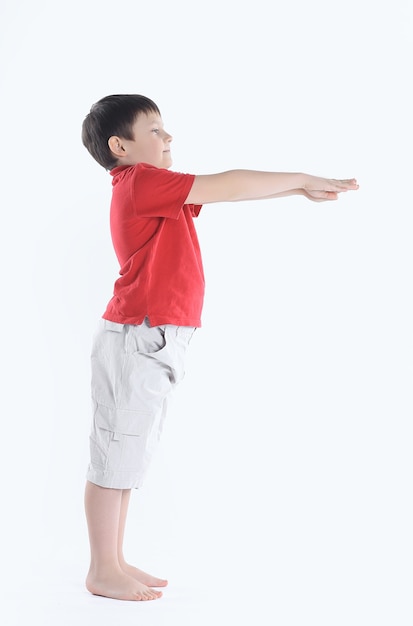 El niño pequeño se está preparando para realizar gimnasia matutina.Aislado en blanco.