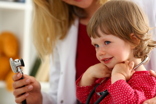 Niño pequeño con estetoscopio en la recepción del médico
