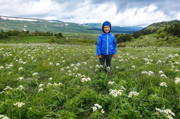 Un niño pequeño en los florecientes prados alpinos de LagoNaki Adygea Russia 2021