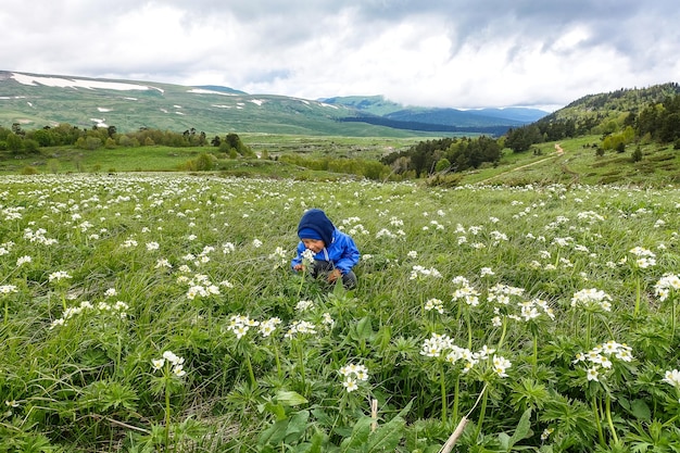 Un niño pequeño en los florecientes prados alpinos de LagoNaki Adygea Russia 2021