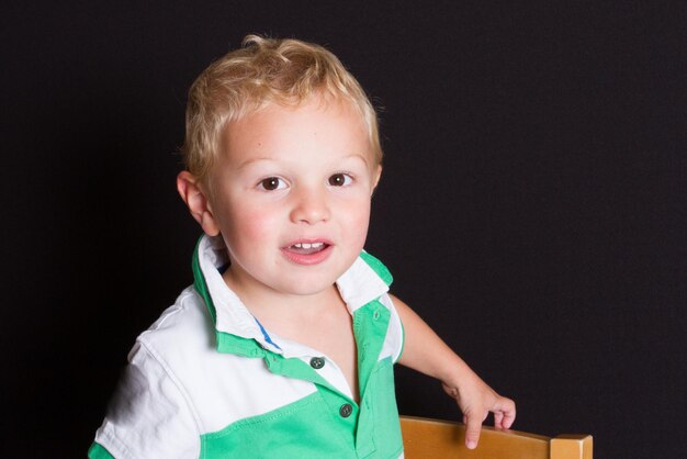 Niño pequeño en fondo negro sonrisa y feliz