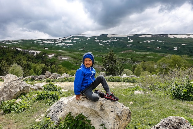 Un niño pequeño en el fondo de los prados alpinos de la meseta de LagoNaki en Adiguesia Rusia 2021