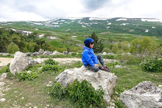 Un niño pequeño en el fondo de los prados alpinos de la meseta de LagoNaki en Adiguesia Rusia 2021