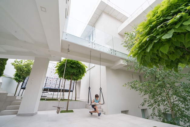 Niño pequeño frente a casa moderna