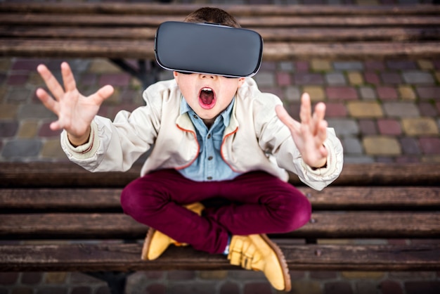 Niño pequeño en gafas de realidad virtual en el parque