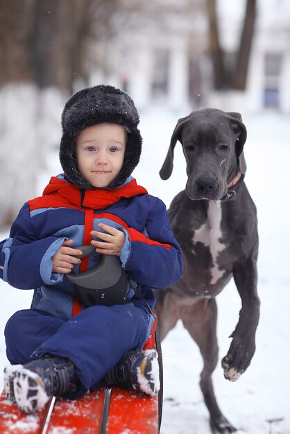 niño pequeño con una gran raza de perro negro