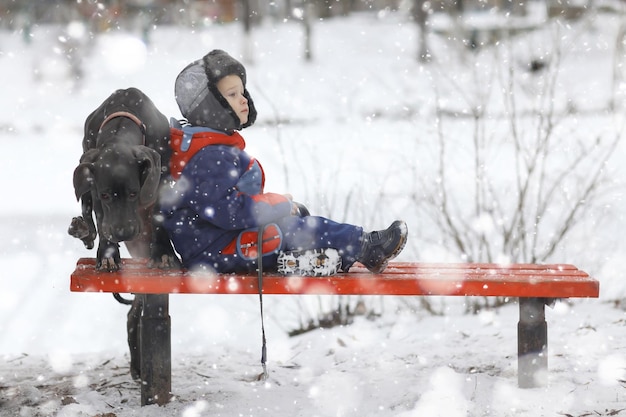 niño pequeño con una gran raza de perro negro