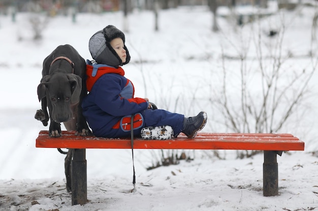 un niño pequeño con una gran raza de perro negro