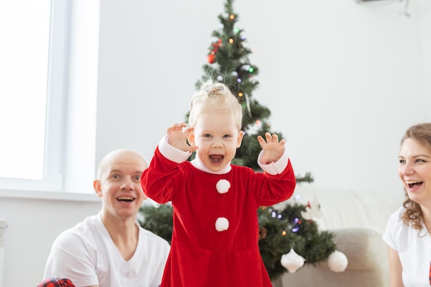 Niño pequeño con implante coclear felizmente grita sordera de fondo del árbol de navidad e innovación de tecnologías médicas para audífonos