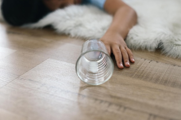 Niño pequeño inconsciente tendido en el suelo con vidrio caído concepto de accidente o desmayo