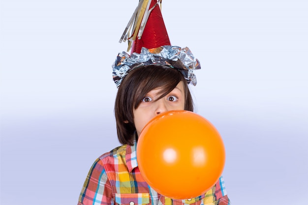 Niño pequeño inflando un globo.